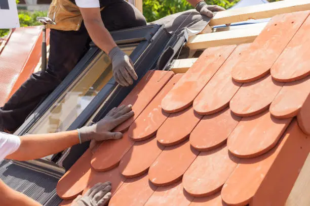 Installation de tuiles sur une toiture rénovée par les techniciens de Photo Climat